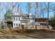 Beautiful home exterior featuring a spacious deck and a hot tub, surrounded by mature trees at 7116 Asheway Dr, Holly Springs, NC 27540