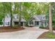 Charming home and detached garage nestled among mature trees with a circular driveway at 7116 Asheway Dr, Holly Springs, NC 27540
