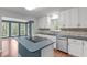 Bright kitchen with white cabinets, blue island and countertops, and stainless steel appliances at 7116 Asheway Dr, Holly Springs, NC 27540