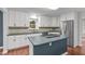 Beautiful kitchen with white cabinets, blue island and countertops, and stainless steel appliances at 7116 Asheway Dr, Holly Springs, NC 27540