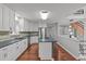 Open-concept kitchen with white cabinets, a blue island, and stainless steel appliances and an open view at 7116 Asheway Dr, Holly Springs, NC 27540