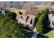 Aerial view of a luxurious home surrounded by lush greenery and a serene lake at 7516 Orchard Crest Ct, Apex, NC 27539
