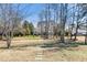 Large grassy backyard with mature trees, walking path and a play set at 7516 Orchard Crest Ct, Apex, NC 27539