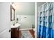 Quaint bathroom featuring a dark wood vanity and decorative vanity mirror and ruffled shower curtain at 7516 Orchard Crest Ct, Apex, NC 27539