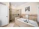 A bright bathroom featuring a tile shower, soaking tub with jets, and neutral décor at 7516 Orchard Crest Ct, Apex, NC 27539