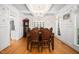 Chandelier illuminates formal dining room with wainscoting, hardwood floors and traditional furnishings at 7516 Orchard Crest Ct, Apex, NC 27539