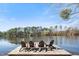 A dock with four chairs sit on a lakefront at 7516 Orchard Crest Ct, Apex, NC 27539