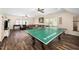 Expansive game room featuring ping pong table, sectional sofa, and hardwood floors at 7516 Orchard Crest Ct, Apex, NC 27539