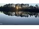 Beautiful sunset reflects off lake with a treeline at 7516 Orchard Crest Ct, Apex, NC 27539