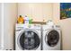 Laundry room featuring a modern washer and dryer with overhead storage cabinets at 7516 Orchard Crest Ct, Apex, NC 27539