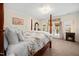A bright main bedroom showcasing a four-poster bed, fireplace, and outdoor access at 7516 Orchard Crest Ct, Apex, NC 27539