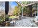 A covered patio with a stone floor, seating, plants, and a view of the backyard at 7516 Orchard Crest Ct, Apex, NC 27539
