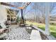 An outdoor stone patio featuring a pergola, stone seating, and a view of the landscaped yard at 7516 Orchard Crest Ct, Apex, NC 27539