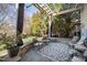 An outdoor patio features a stone floor, seating, plants, and views of the green backyard at 7516 Orchard Crest Ct, Apex, NC 27539
