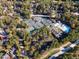 Aerial view featuring tennis courts, a pool, and clubhouse nestled among lush trees and landscape at 81008 Alexander, Chapel Hill, NC 27517