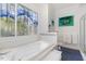 This main bathroom features blue tiled floors, a soaking tub, and a uniquely-styled stained glass window at 81008 Alexander, Chapel Hill, NC 27517
