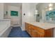 This main bathroom features a double vanity, blue tiled floors, an oversized mirror, and artistic accents at 81008 Alexander, Chapel Hill, NC 27517