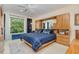 This main bedroom has an integrated wooden dresser, carpeted floors, large windows, and a blue quilted comforter at 81008 Alexander, Chapel Hill, NC 27517