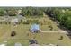 Aerial view of a home with a metal roof, set on a spacious lot, surrounded by lush greenery and neighboring properties at 8163 Julian Rd, Dunn, NC 28334