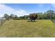 View of the property's spacious back yard featuring a small storage shed and mature trees at 8163 Julian Rd, Dunn, NC 28334