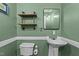 Compact powder room featuring pedestal sink, toilet, and industrial shelving at 8163 Julian Rd, Dunn, NC 28334