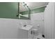White tiled bathroom featuring a single vanity, mirror, toilet, shower with curtain, and hexagon patterned floors at 8163 Julian Rd, Dunn, NC 28334