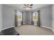 Neutral bedroom with carpet, two windows with nature views, ceiling fan, and decorative trunk at 8163 Julian Rd, Dunn, NC 28334