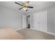Bright and airy carpeted bedroom featuring a ceiling fan, closet and doorway to another room at 8163 Julian Rd, Dunn, NC 28334