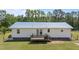 Exterior view of a white home featuring a metal roof, a small deck, and a well-maintained lawn at 8163 Julian Rd, Dunn, NC 28334