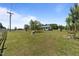 View of the property's expansive front yard featuring a rock sculpture and mature trees at 8163 Julian Rd, Dunn, NC 28334