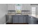 Traditional kitchen featuring painted cabinets, stainless steel dishwasher, light countertops, and a view from the window at 8163 Julian Rd, Dunn, NC 28334