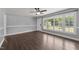 Well-lit living room featuring laminate flooring, a ceiling fan, and a large bright window at 8163 Julian Rd, Dunn, NC 28334
