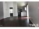 Spacious living room with hardwood floors that flows into the kitchen and breakfast bar at 8908 Shallcross Way, Raleigh, NC 27617