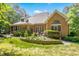 Brick home's backyard showcases a well-manicured lawn, a low-wall garden, and brick exterior at 10011 Hammock Bnd, Chapel Hill, NC 27517