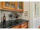Wet bar displays glass and wine storage over granite counters with warm wood cabinets and a wine refrigerator at 10011 Hammock Bnd, Chapel Hill, NC 27517