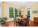 Sun-drenched dining area with hardwood floors, a large window with a view, and a charming light fixture at 10011 Hammock Bnd, Chapel Hill, NC 27517