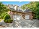 Brick home featuring garage, driveway, and lush landscaping at 10011 Hammock Bnd, Chapel Hill, NC 27517