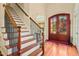 Elegant foyer with hardwood floors, staircase, and arched doorway, showcasing classic architectural details at 10011 Hammock Bnd, Chapel Hill, NC 27517