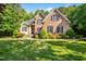 Beautiful brick home with manicured lawn, flowering shrubs, and mature trees for an inviting curb appeal at 10011 Hammock Bnd, Chapel Hill, NC 27517