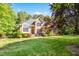 Charming brick home with manicured lawn, lush greenery and classic architectural details creates a welcoming exterior at 10011 Hammock Bnd, Chapel Hill, NC 27517
