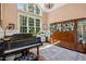 Bright, airy living room with a piano, large window, and classic furnishings providing an elegant space at 10011 Hammock Bnd, Chapel Hill, NC 27517