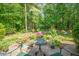 Landscaped patio area with flowers, a small table, and chairs provides a tranquil outdoor setting at 10011 Hammock Bnd, Chapel Hill, NC 27517