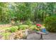 The patio features a small table, potted plants and flowers that accentuates the lovely, wooded outdoor area at 10011 Hammock Bnd, Chapel Hill, NC 27517