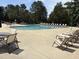 Community outdoor pool with lounge chairs and trees at 10011 Hammock Bnd, Chapel Hill, NC 27517