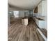 Spacious kitchen with white cabinetry, a dark wood island, hardwood flooring, and open to the living room at 1002 Canterbury Rd, Raleigh, NC 27607