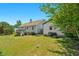 View of the backyard featuring a deck, garage, lawn, and mature trees at 109 N Valley Dr, Louisburg, NC 27549