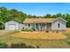 Charming home featuring light grey siding, a welcoming porch, and a detached garage at 109 N Valley Dr, Louisburg, NC 27549