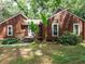Charming brown two-story home featuring a quaint front porch entrance and green lawn at 112 Cameron Ct, Cary, NC 27511