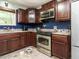 Kitchen featuring wooden cabinets, stainless steel appliances, and granite countertops at 112 Cameron Ct, Cary, NC 27511