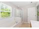 Well-lit bathroom with garden tub, separate shower, and a bright window at 11710 Mezzanine Dr # 101, Raleigh, NC 27614